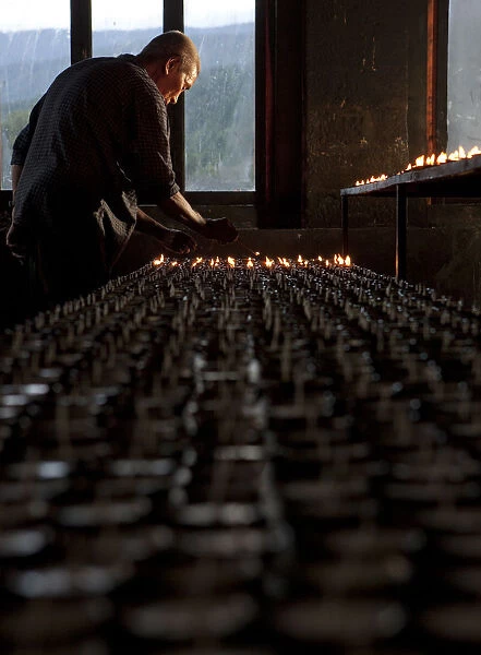 A man lighting candles in a temple in Bhutan