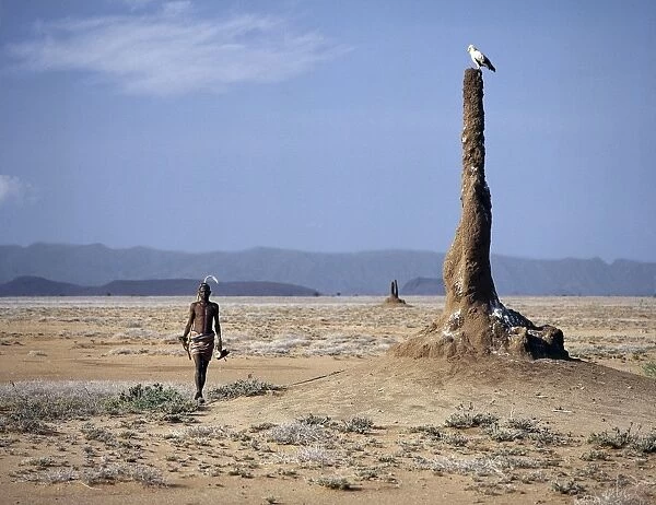 A Turkana man strides purposefully across the treeless
