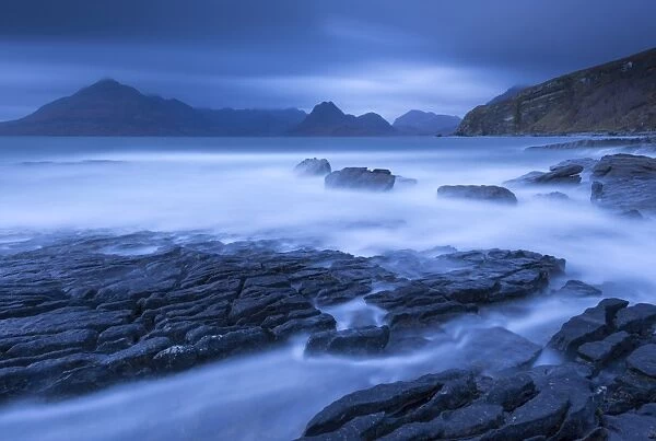 Twilight on the rocky coast of Elgol, looking across to the Cuillin mountains, Isle of Skye