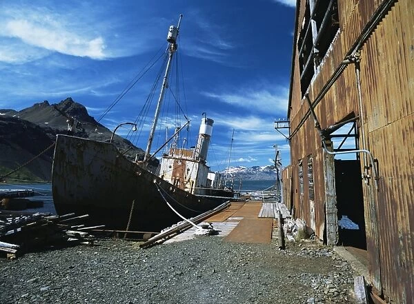 Remains of old whaling station, with deserted buildings and boat in dock, Falkland Islands