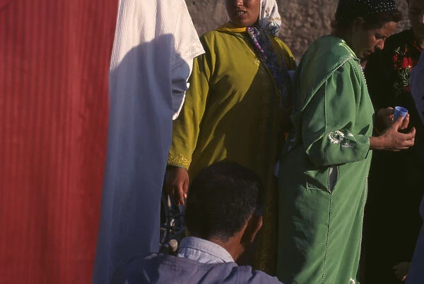 10010228. MOROCCO General Women at souk in bright coloured clothing Market