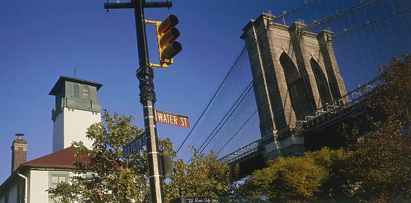 20019195. USA New York Part view of Brooklyn Bridge seen above trees with road sign