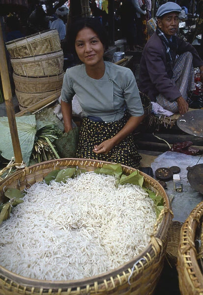 20039058. MYANMAR Markets Young woman selling noodles on market stall near Inle Lake