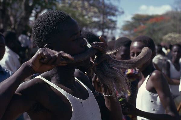 20041436. TANZANIA Dodoma Ngomas dancers using an animal horn as a musical instrument