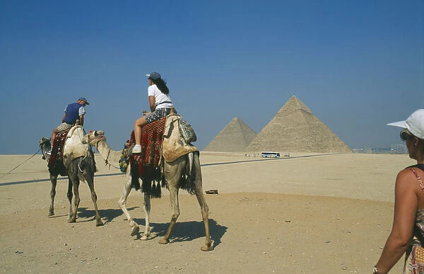 20050098. EGYPT Cairo Tourists on camels visiting the pyramids