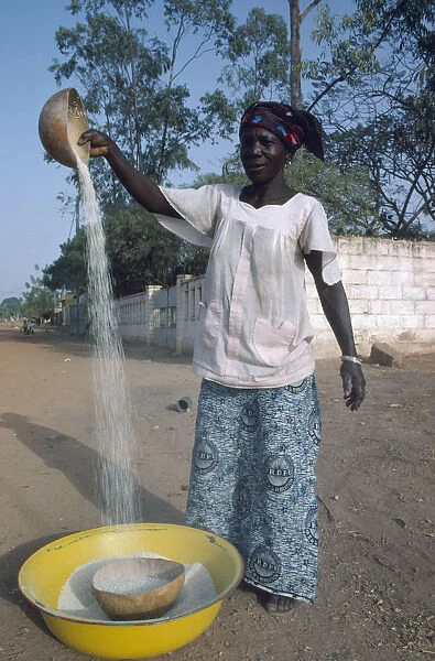 20061291. BURKINA FASO Ouagadougou Woman winnowing rice.West Africa