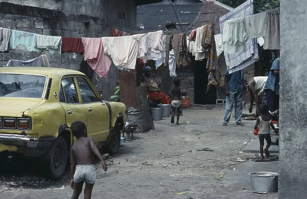 20070601. CONGO Kinshasa Housing for extended family with parked car and hanging washing