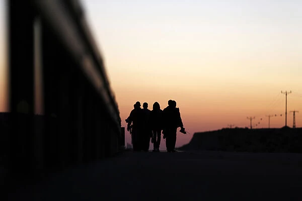 African migrants walk on a road after choosing to permanently leave their open detention