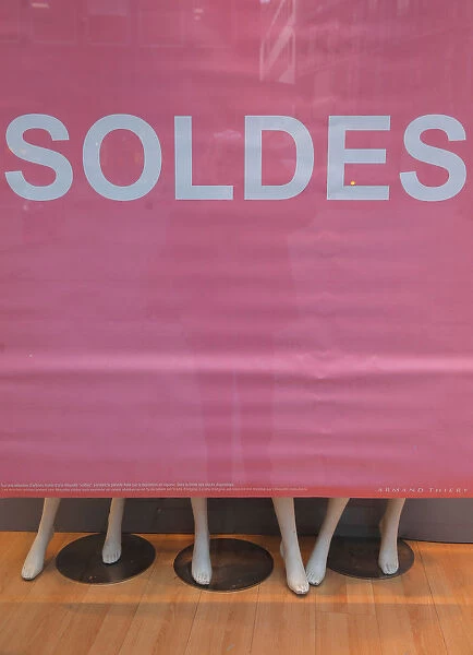 A banner announces Sales on a clothing store front window during the start of winter