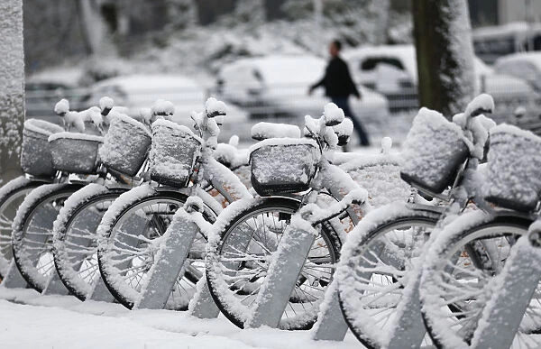 Bicycles are covered in snow following heavy snowfall in the western German city of