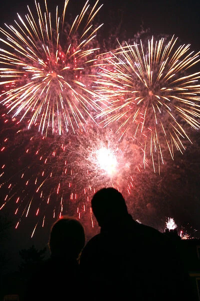 A couple watches fireworks explode over Kew Gardens in London