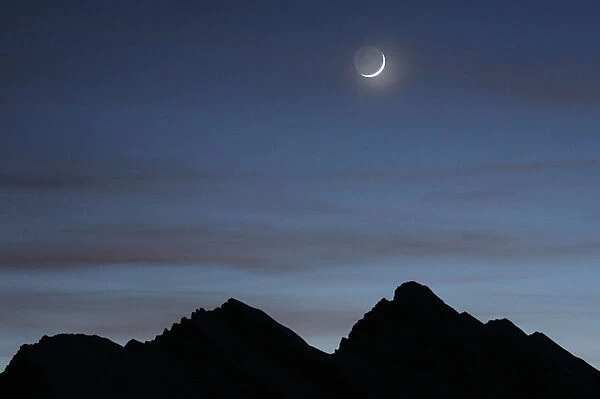 A crescent moon is pictured above mountains at the Kleine Scheidegg in Wengen January