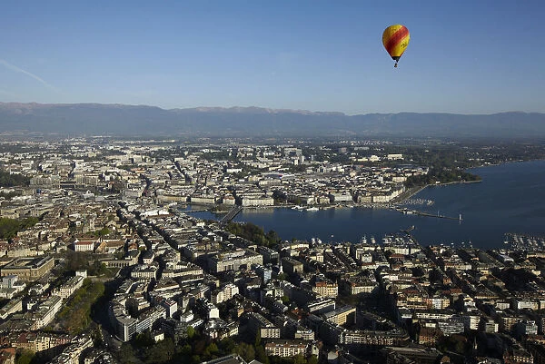 A hot air balloon flies above the city of Geneva