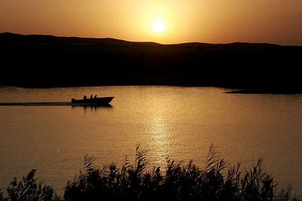 Iranians travel in boat on a lake in southern Tehran