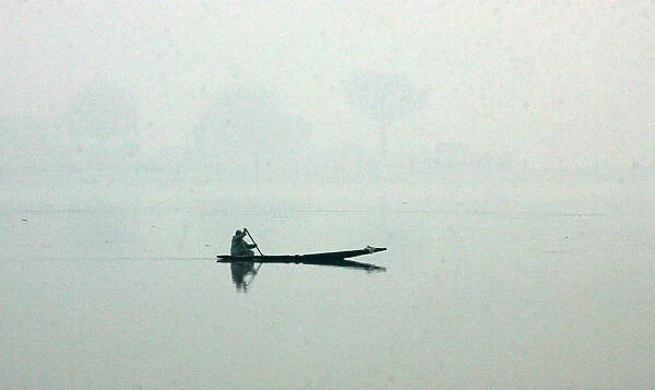 Kashmiri woman rows her boat on Dal Lake in Srinagar