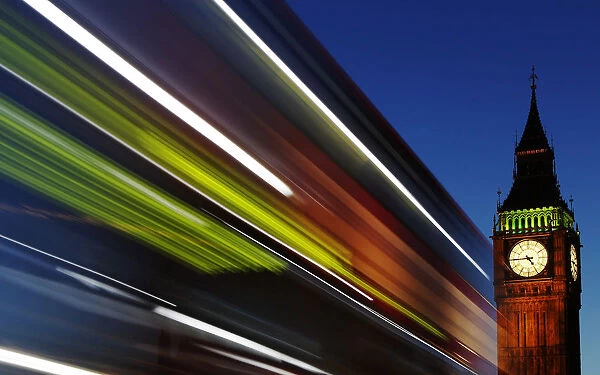 Light trails shine from a passing bus in front of Big Ben and the Houses of Parliament