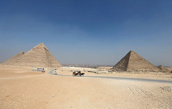 Tourists ride in horse carts in the Giza pyramids area, on the outskirts of Cairo