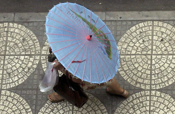 Woman carries umbrella in Tirana
