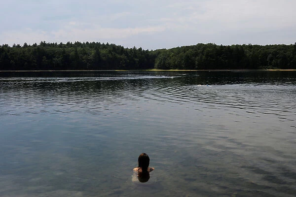 A woman swims in Walden Pond on what would have been the 200th birthday of Henry David