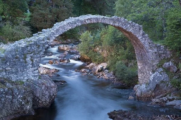 Old packhorse bridge over river at dusk, River Dulnain, Carrbridge, Badenoch and Strathspey, Highlands, Scotland, July