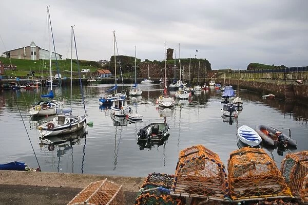 View of harbour with lobster pots, boats and ruined castle in background, Dunbar Castle, Dunbar Harbour, Dunbar