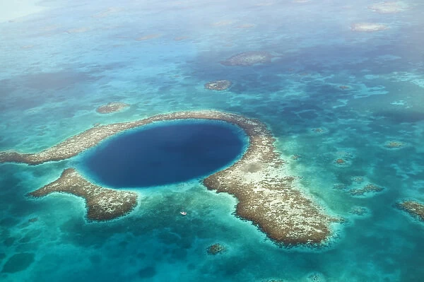 aerial view of Blue Hole, sailboat anchored nearby, Lighthouse Atoll, Belize