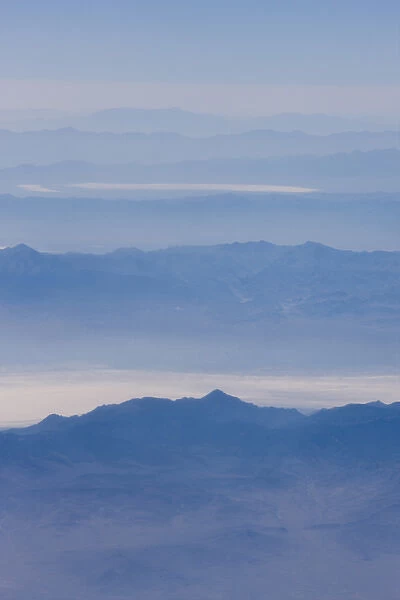 An aerial view of smoke covered mountain peaks and valleys in eastern California