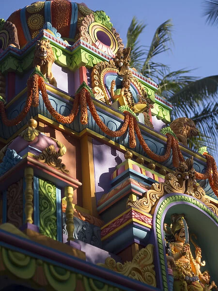 A colorful Hindu temple is decorated with colors and flower wreaths in Bangalore