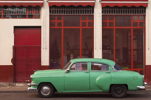 Cuba, Havana. Green car, red building on the streets