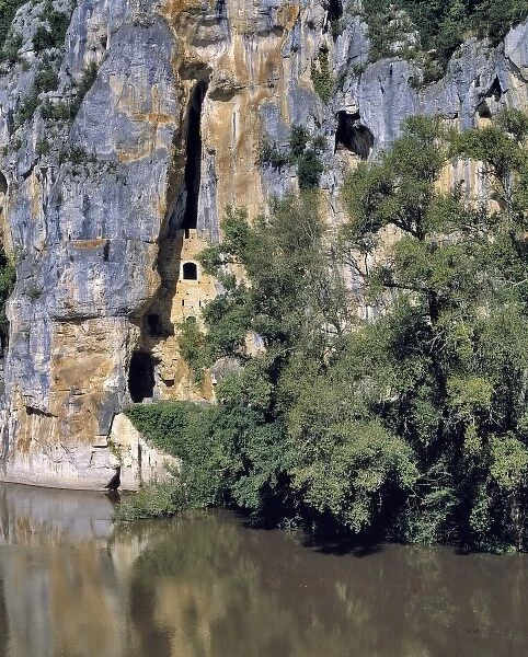 Europe, France, Lot River. Caves are carved into the limestone cliffs near St. Cirq