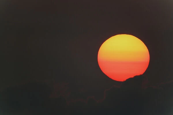 USA, Florida, Blue Cypress Lake. Sunrise orange and yellow globe with clouds. Credit as