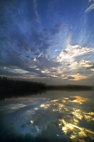 USA, Michigan, Upper Peninsula. Sunrise sky reflected in Petes Lake