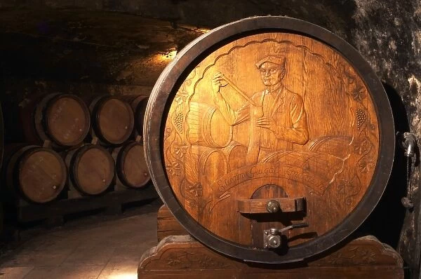 Wooden storage vat with aging wine of Guigal in Ampuis. The end of the vat is carved