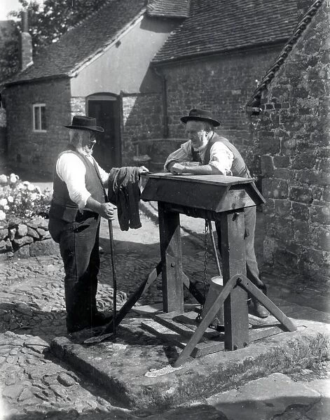 Two country gentlemen chatting by a well at Upperton, Sussex. August 1936