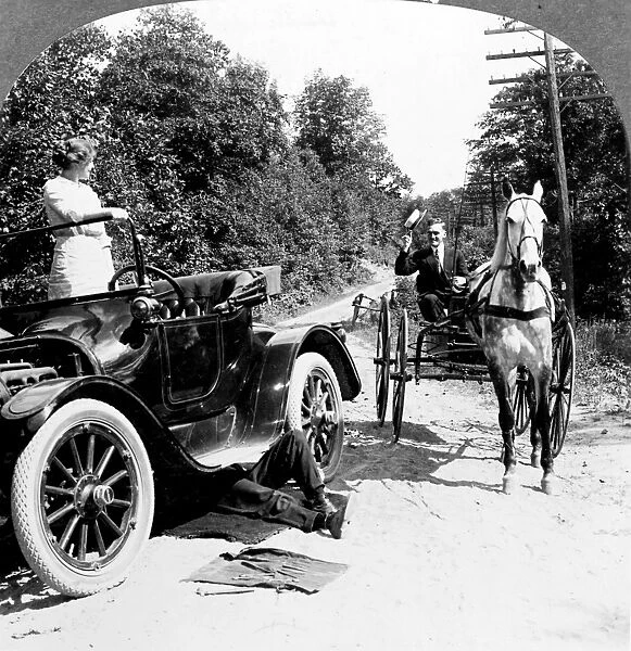 CAR AND CARRIAGE, 1914. A horse and carriage meets a broken down car on a road