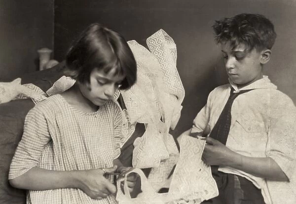 HINE: CHILD LABOR, 1924. A young girl and boy cutting lace at home in New York City