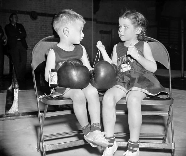 JUNIOR BOXER, 1939. Dorothy Wood, age 5, laces the boxing gloves of her companion, Chuck Andrews, age 3, at the U. S. Naval Academys 20th Annual Junior Boxing Championships, in Annapolis, Maryland, 1939