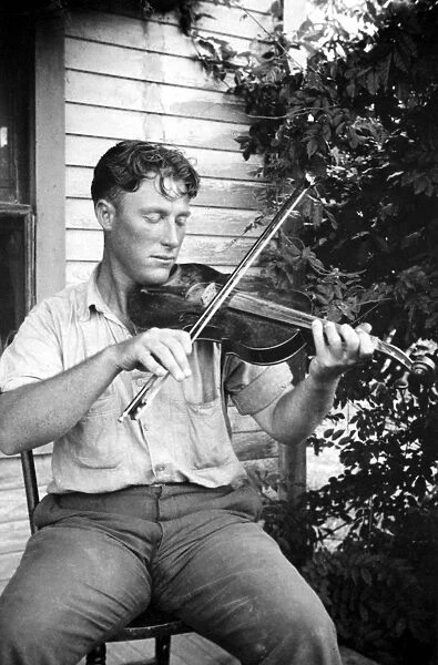 LOUISIANA: FIDDLER. Wayne Perry playing the fiddle on a porch in Crowley, Louisiana