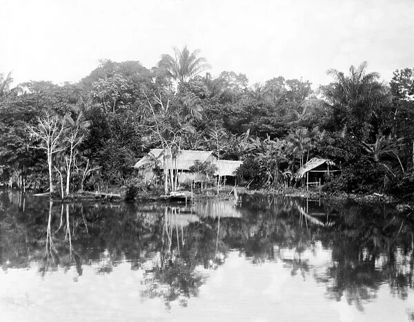 NATIVE BRAZILIANS. Native Brazilian huts in a clearing on a river bank in Brazil