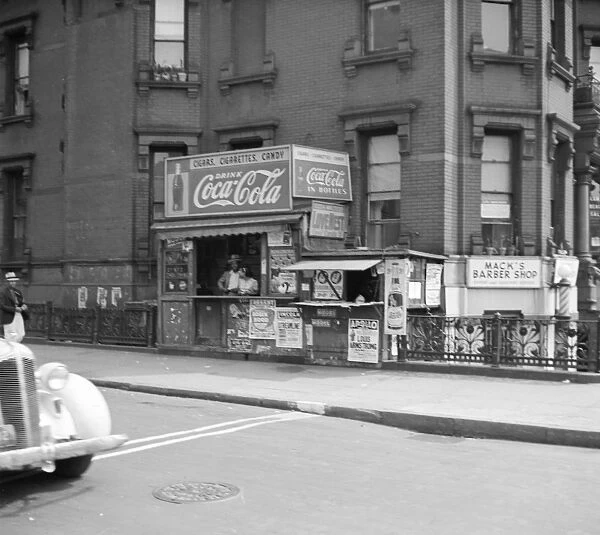 NEW YORK CITY, 1938. A newsstand on the street in Harlem, New York City