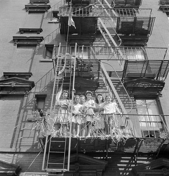 NEW YORK: MOTT STREET, 1942. Italian-American women on a fire escape watching a parade