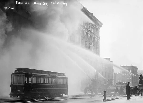 NYC: FIRE, 1909. Firemen spraying a burning building on 14th Street in New York City