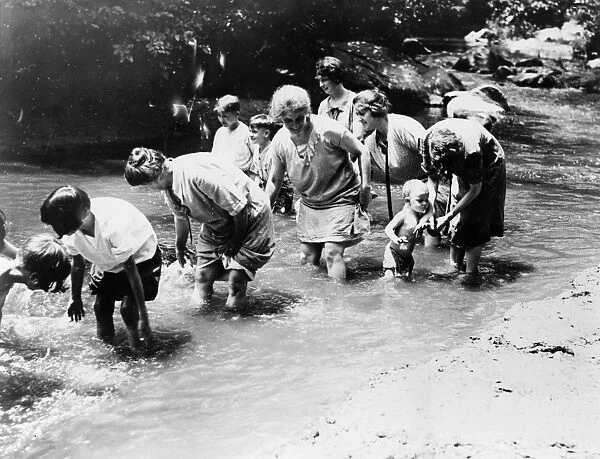 ROCK CREEK: WADING. Adults and children wading in Rock Creek Park, a tributary