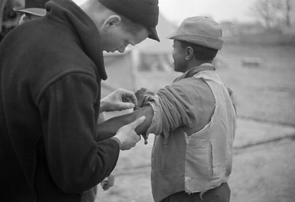 VACCINATION, 1937. A doctor administering vaccinations in the camp for African