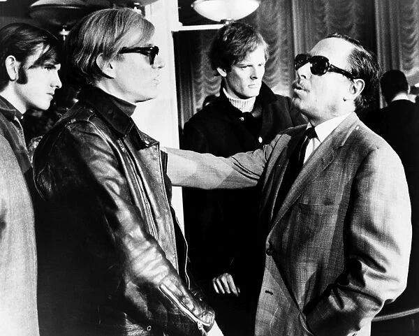 WARHOL AND WILLIAMS, 1967. American artist and filmmaker Andy Warhol (left) speaking with American playwright Tennessee Williams aboard the S. S. France, 1967. Photographed by James Kavallines