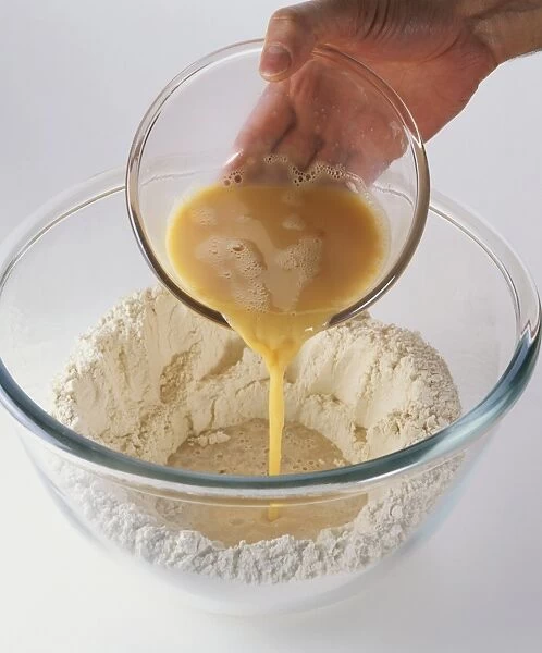Adding beaten eggs from small mixing bowl to brioche dough in large mixing bowl