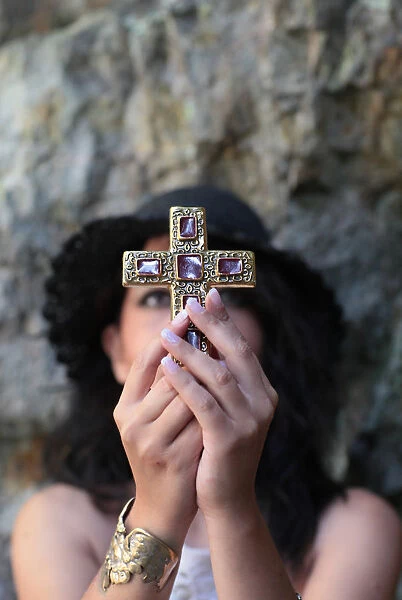 Christian woman praying with a cross