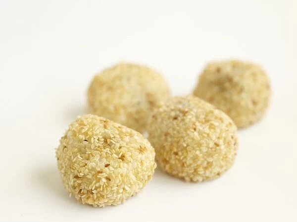 Daifukumochi, four round Japanese sweets sprinkled with sesame seeds