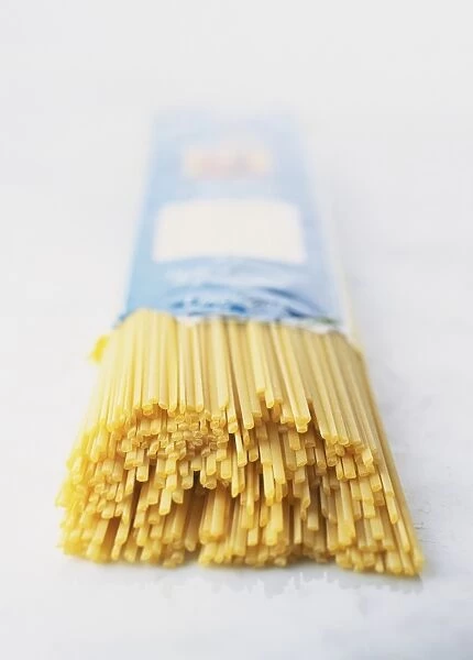 Dried linguine sticking out of an opened packet, close up