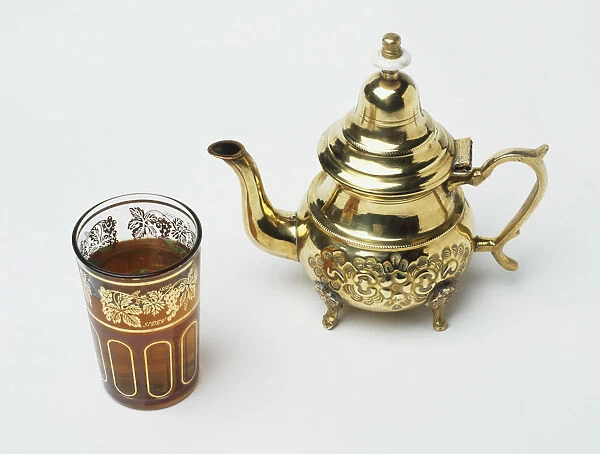 Gold teapot and glass of sweet mint tea